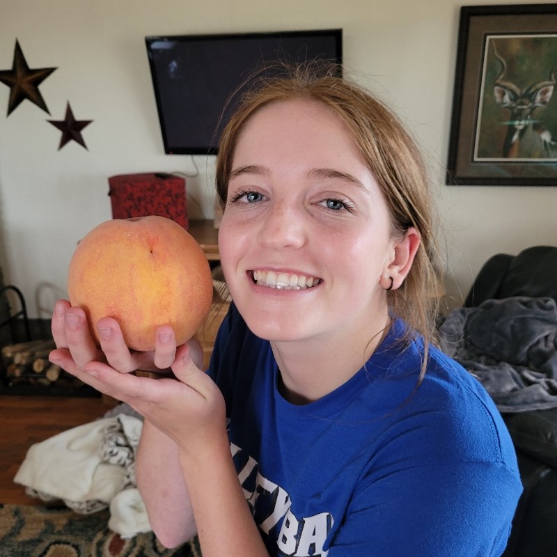 Lance's daughter holding a peach